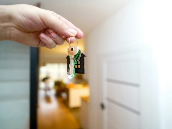 Remise des clés devant l’entrée d’un logement, illustrant le préavis de départ en location